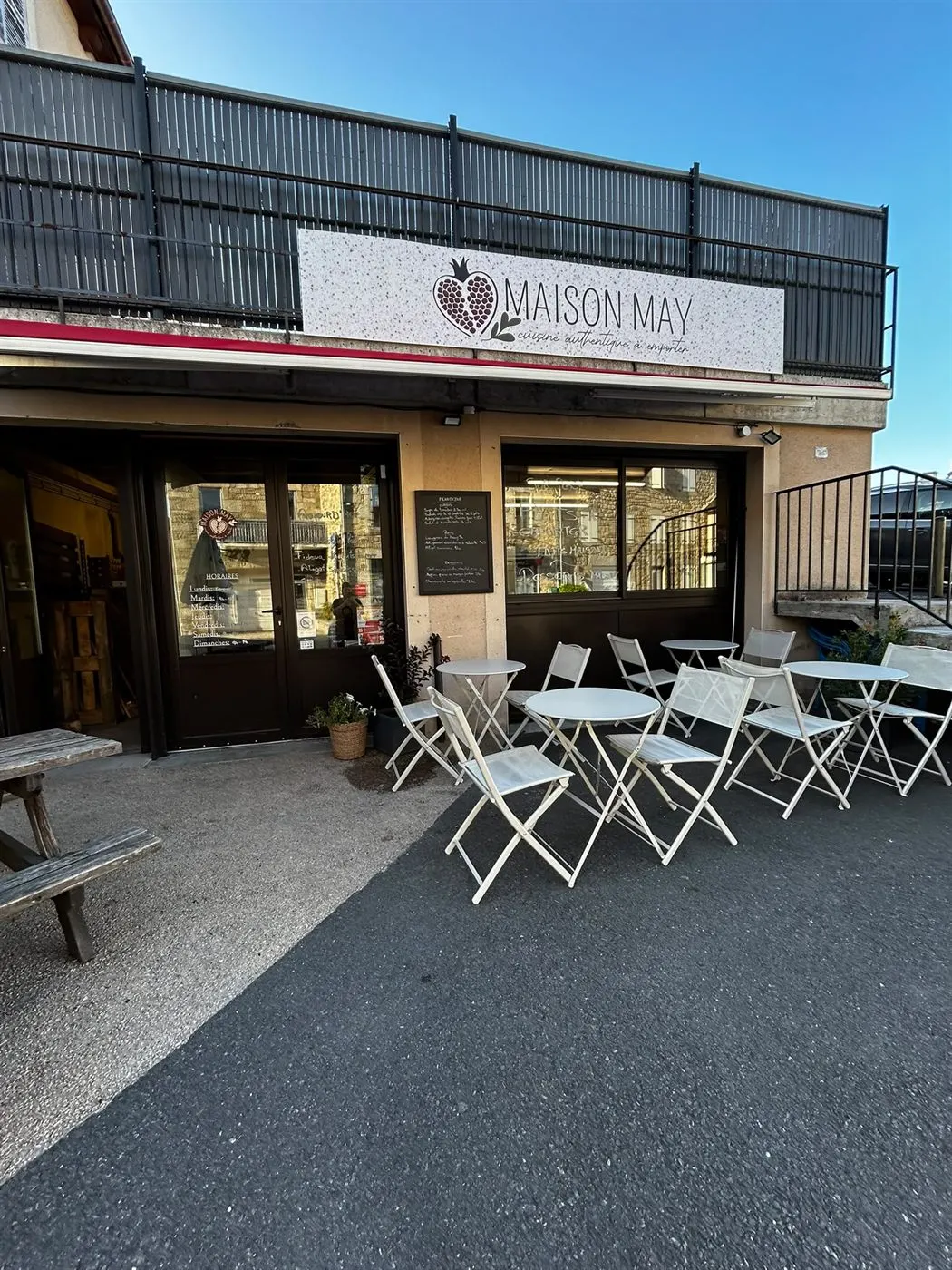 La terrasse de Maison May au soleil, tables et chaises devant la boutique